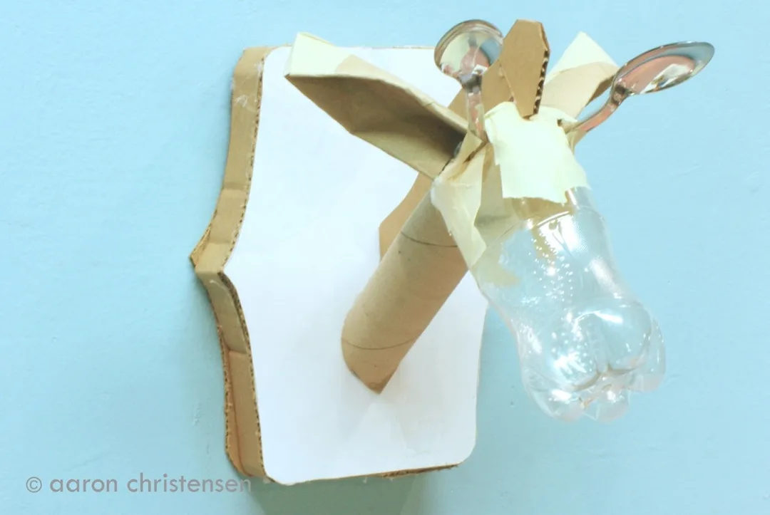 Plastic bottle, cardboard, tape and utensils become a taxidermied garaffe.